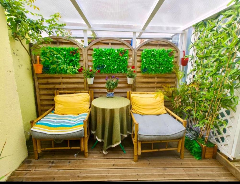 un patio avec une table, des chaises et des plantes dans l'établissement Le Coin des Artistes - Maisonnette, à Giverny