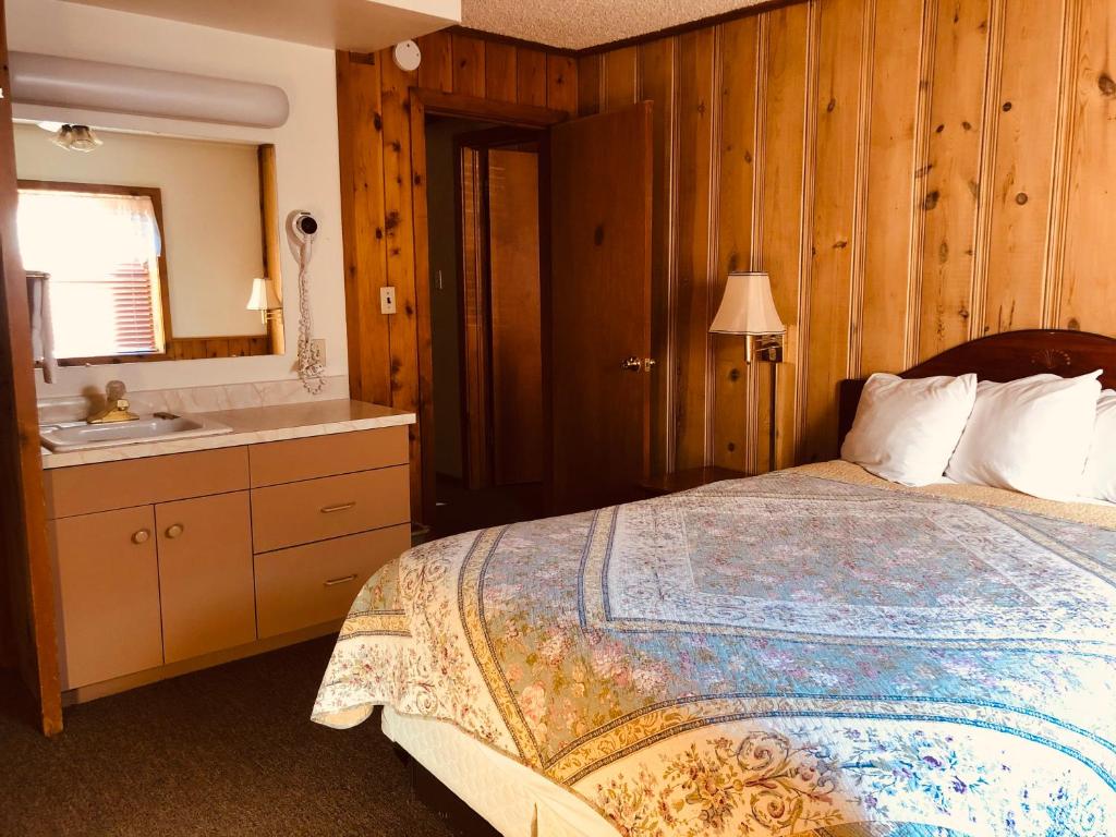 a bedroom with a bed and a bathroom with a sink at Glenwood Springs Cedar Lodge in Glenwood Springs