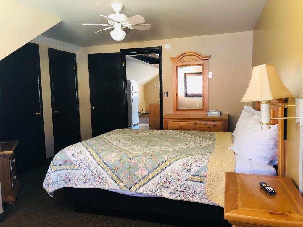 a bedroom with a bed and a lamp and a table at Glenwood Springs Cedar Lodge in Glenwood Springs