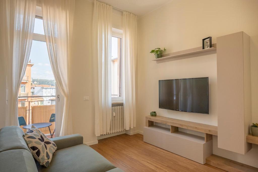 a living room with a couch and a flat screen tv at Romeo e Giulietta Suite in Verona
