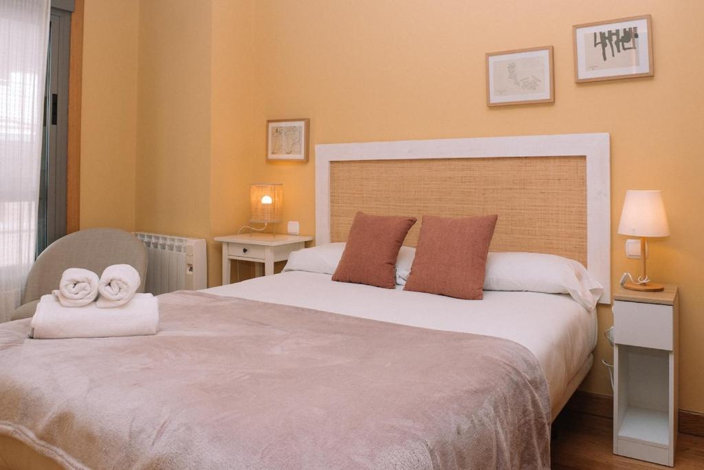 a bedroom with a bed with two towels on it at Cómodo luminoso y céntrico by CABANA Rentals in Vigo