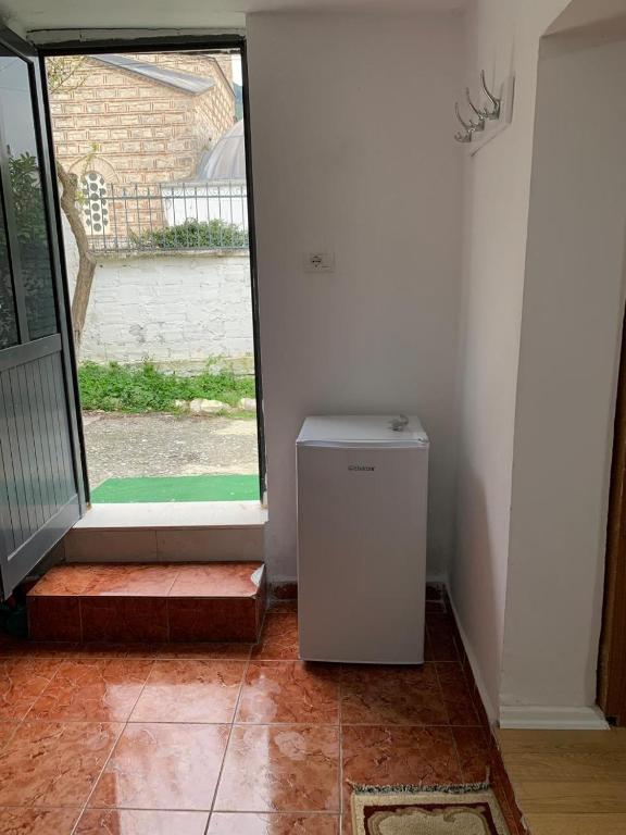 a small refrigerator in a room with an open door at Guesthouse N&B in Berat