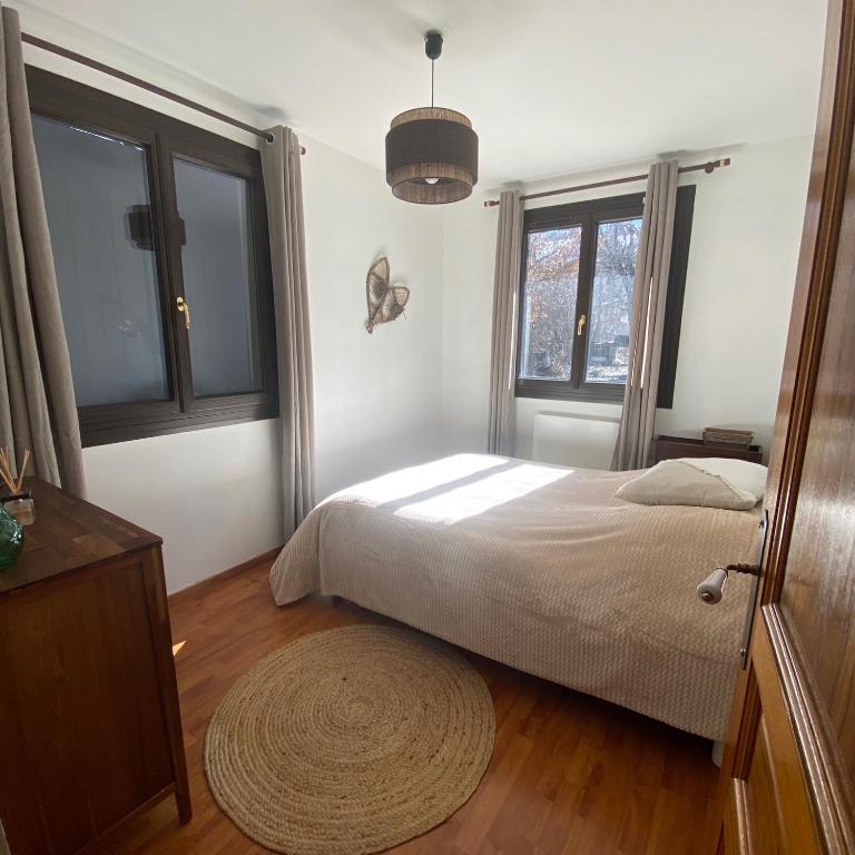 - une chambre avec un lit, 2 fenêtres et un tapis dans l'établissement Chalet cosy à la montagne, à Ancelle