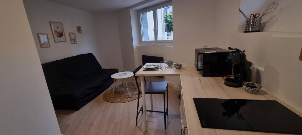 - un petit salon avec une table et un four micro-ondes dans l'établissement Studio cosy Proche de la gare, à Valence