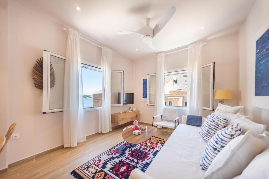 un salon avec un canapé blanc et une table dans l'établissement Finestra Sul Mare Corfu - Sea & Sun Stay, à Corfu