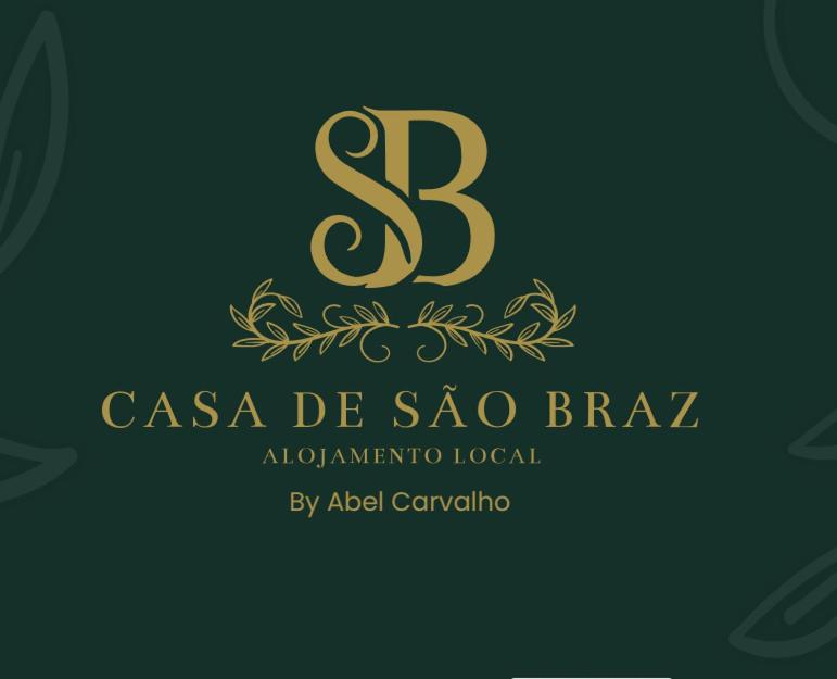 a gold letter s with a laurel border on a green background at Casa de São Braz in Landim