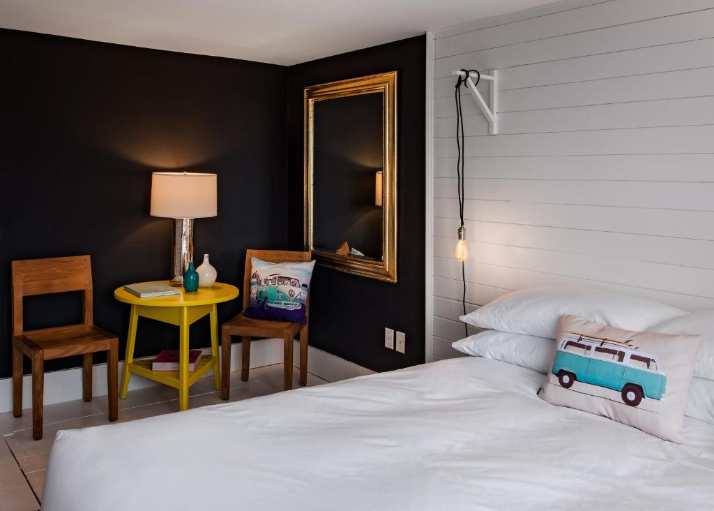 a bedroom with a bed and a mirror and a table at The Waterford Inn in Provincetown