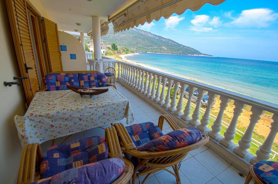 un balcón con sillas y una mesa y la playa en Villa Alba en Kinira