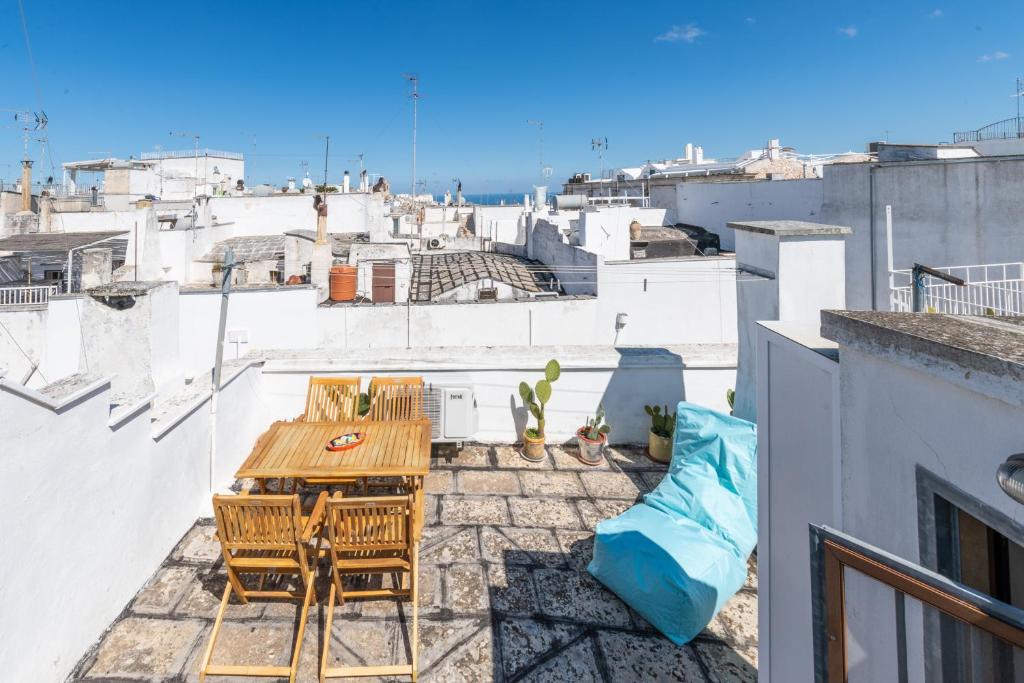 un patio con mesa y sillas en la azotea en Le Piccole Case Bianche, en Ostuni