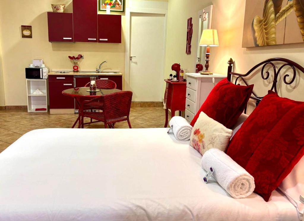 1 dormitorio con 1 cama con almohadas rojas y cocina en Holibai, Vermello, Un rincón con encanto cerca de la playa, en Baiona
