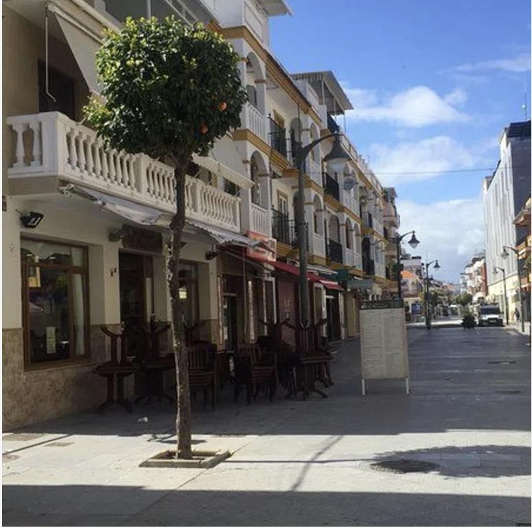 una calle con mesas y sillas en una calle de la ciudad en Apartamento centro Punta Umbría, en Punta Umbría