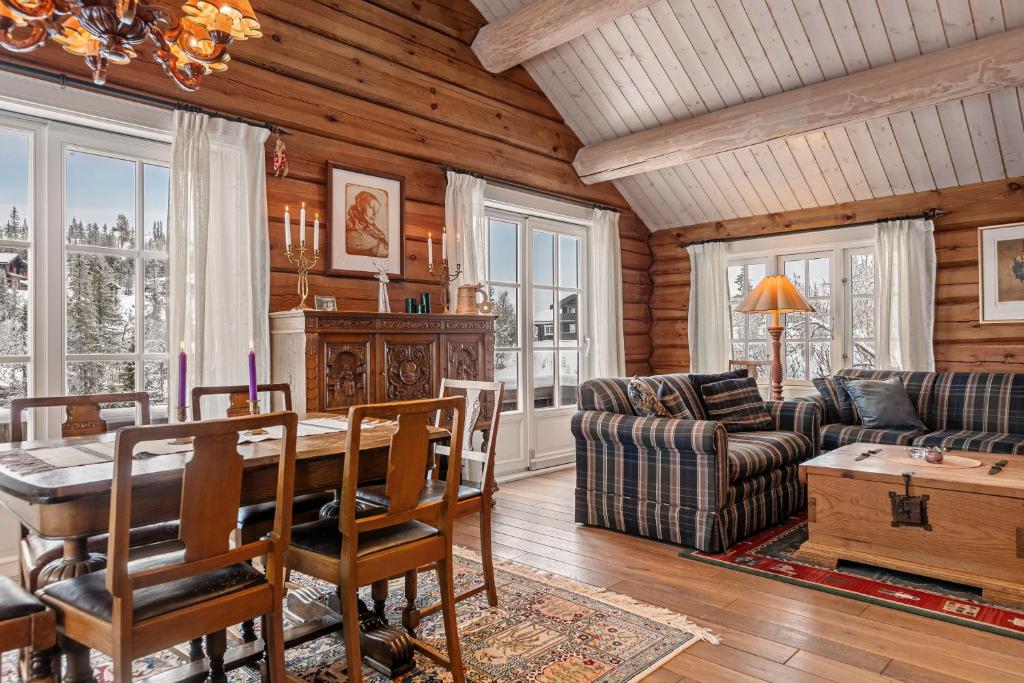 a living room with a table and a couch at Tømmerhytte i Valdres med panoramautsikt over fjellene in Aurdal
