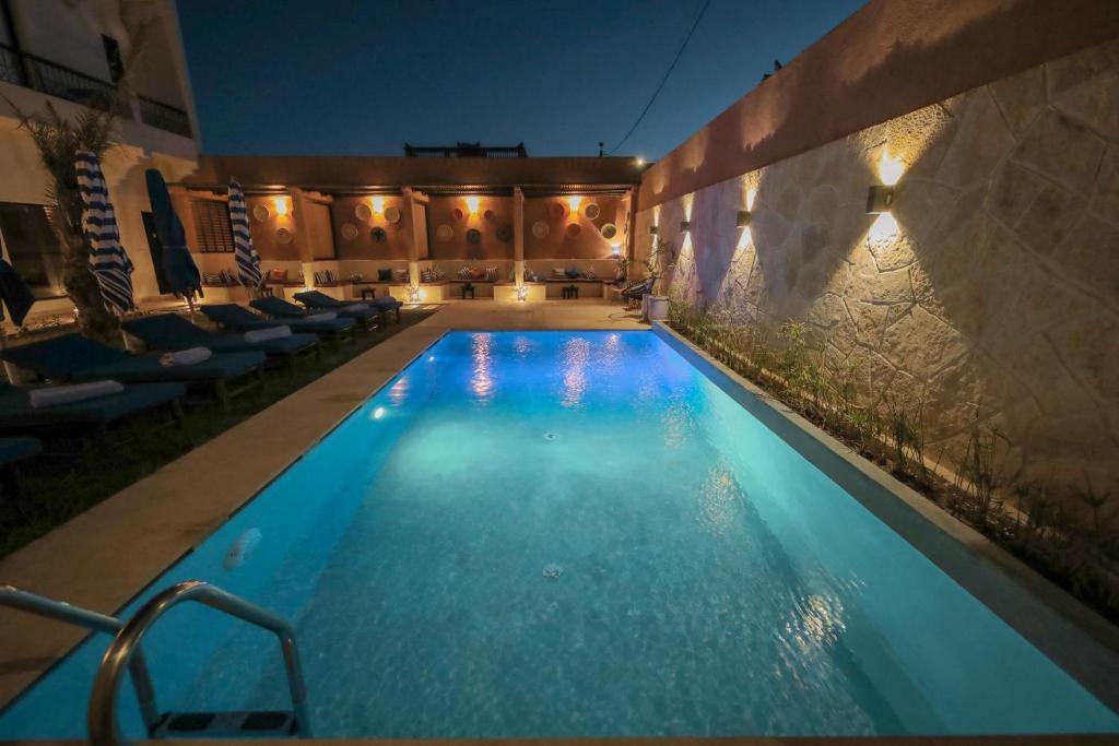 a swimming pool in a hotel at night at Palm View Palace in Ouarzazate