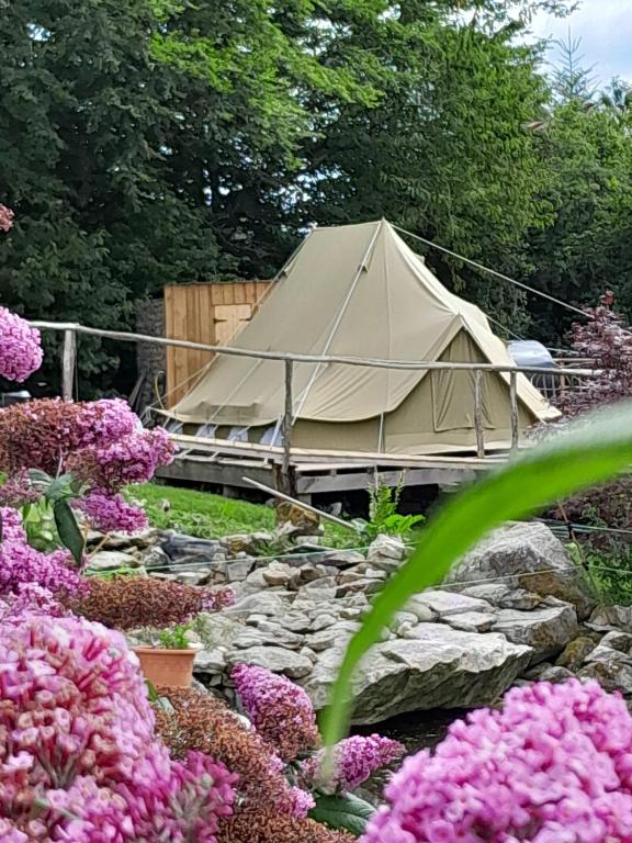 une tente au milieu d'un jardin fleuri dans l'établissement Le monde d'Echozellia - Tente M, à Saint-Germain-des-Champs