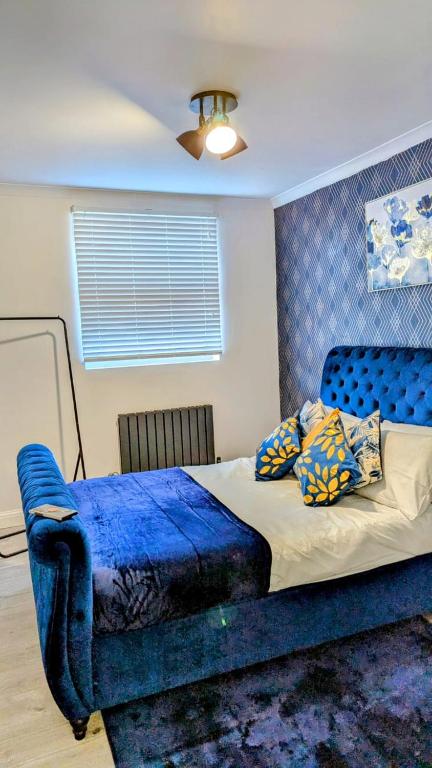 a bedroom with a blue bed with a blue headboard at Crystal Palace Stylish gfloor 1bed apartment,3 minutes walk to Crystal palace station in London