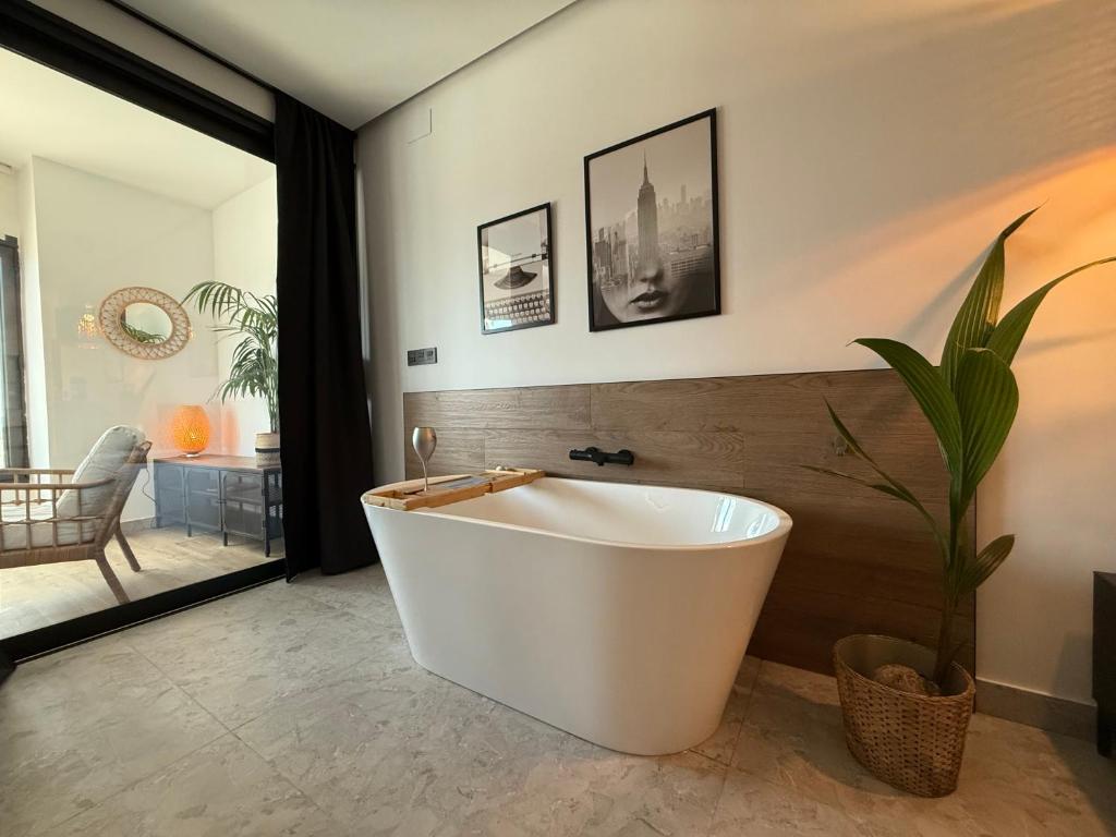 a white bath tub in a bathroom with a plant at Victoria loft in Castell de Ferro