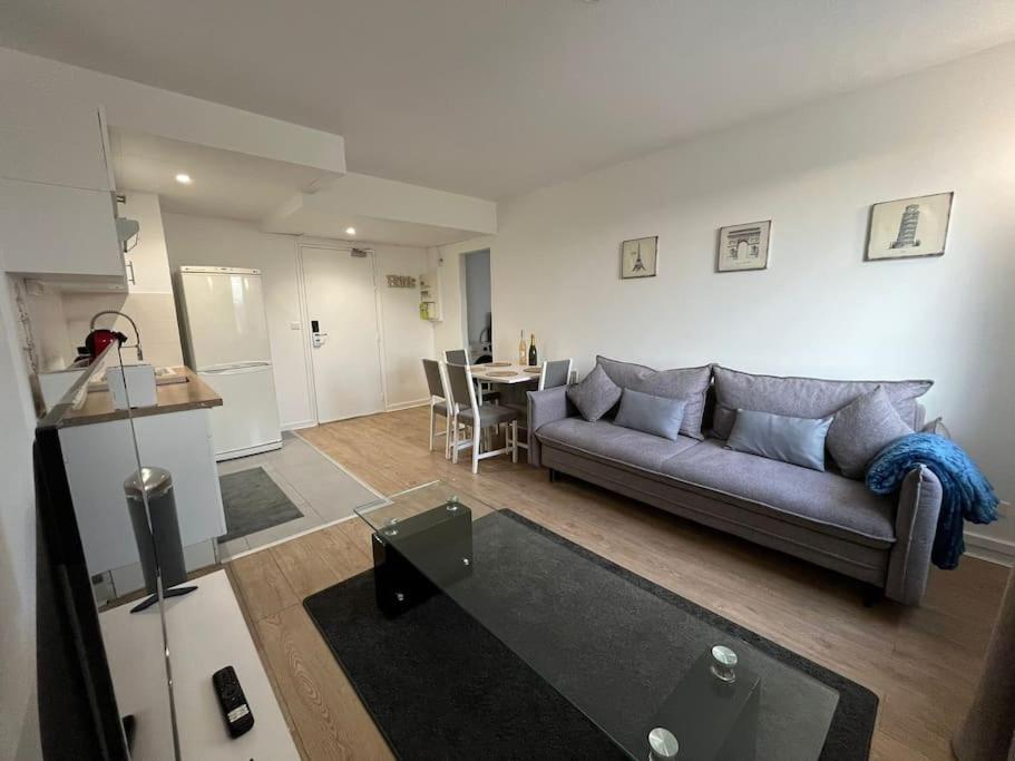 una sala de estar con un sofá y una mesa en L'aile du Moulin, en Magny-le-Hongre