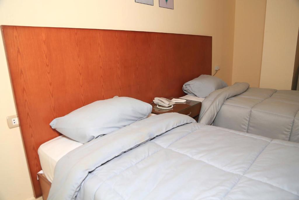 Postel nebo postele na pokoji v ubytování verssailles pyramids hotel
