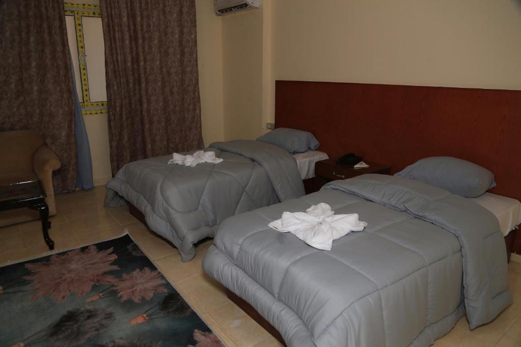 Postel nebo postele na pokoji v ubytování verssailles pyramids hotel