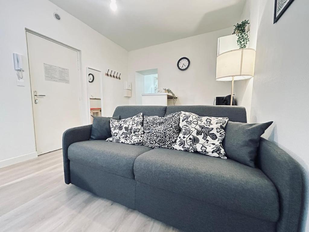 - un canapé bleu avec des oreillers dans le salon dans l'établissement Duruy D studio confort proche piscine et patinoire, à Reims