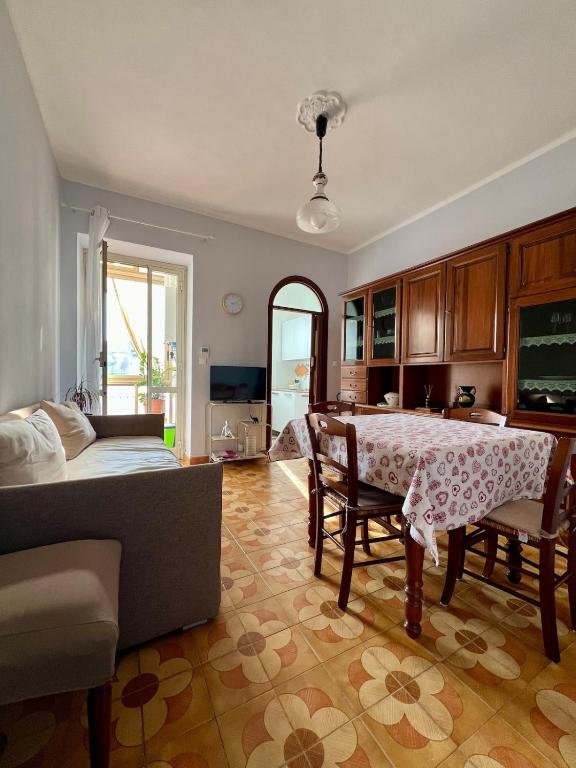 a living room with a table and a couch at La Nina soggiorno felice in Moncalieri