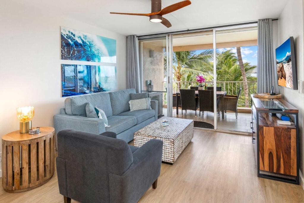 a living room with a blue couch and a table at Oceanfront Modern & Elegant Vistas in Kihei