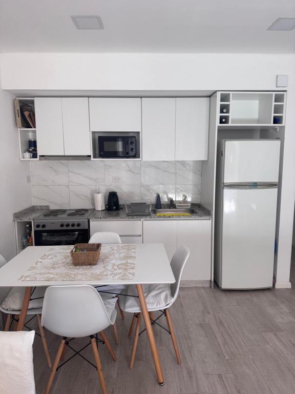 a kitchen with a table and chairs and a refrigerator at Hermoso departamento de 2 ambientes in Pilar