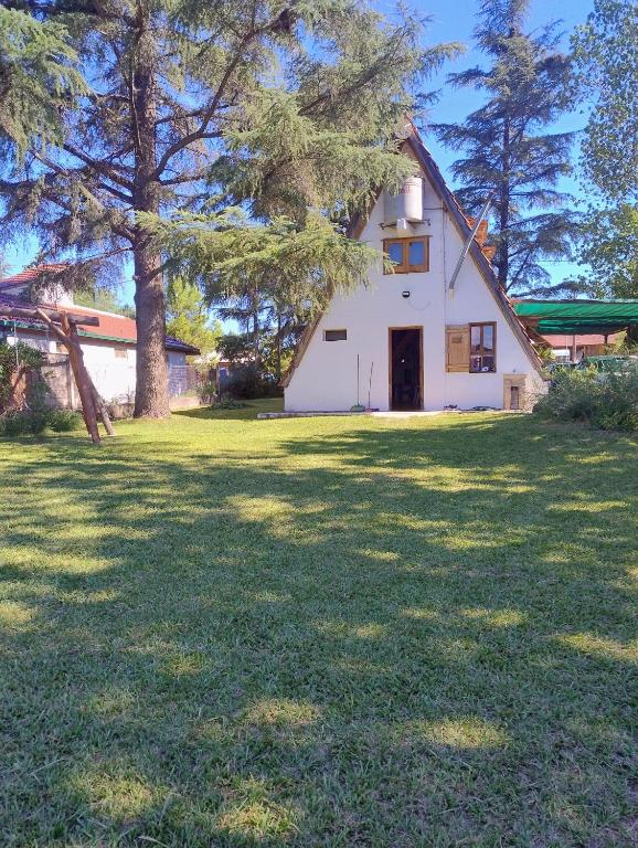 a white house with a large yard with trees at Bungalow San Antonio in San Antonio de Arredondo
