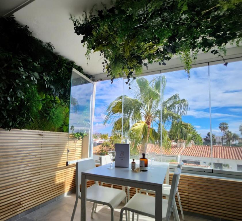 a dining room with a table and chairs and a large window at Yumbo Tinache Luxury Maspalomas in Maspalomas