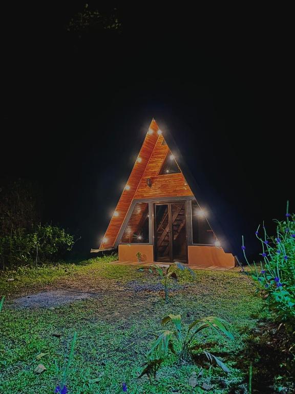 a small wooden house with a light on the side at Pozas y Cascadas La Presa in Río Cuarto
