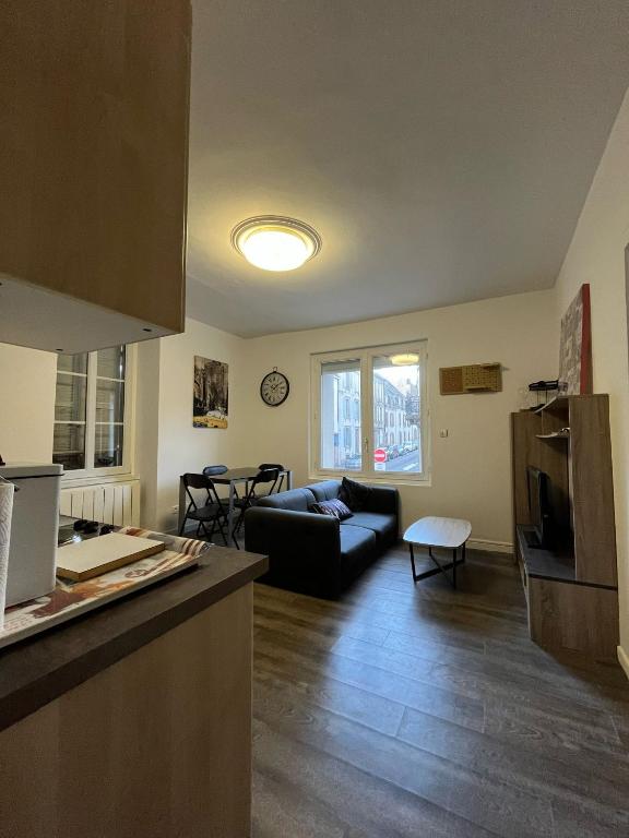 une cuisine et un salon avec un canapé dans l'établissement Au relais de la gare, à Quimper