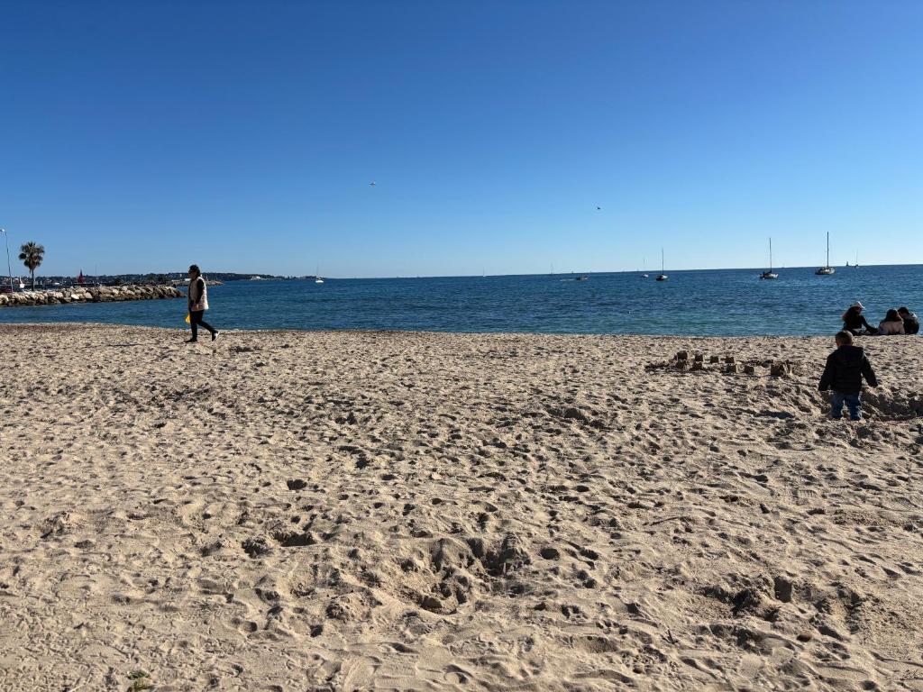 un groupe de personnes marchant sur la plage dans l'établissement Centre Golfe Juan Plage et transports à pied, 5 min Cannes, à Vallauris