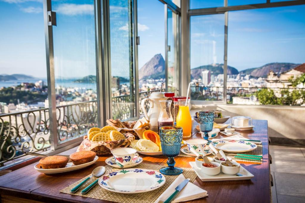 a table with breakfast food and a view of the city at Gerthrudes Bed & Breakfast in Rio de Janeiro