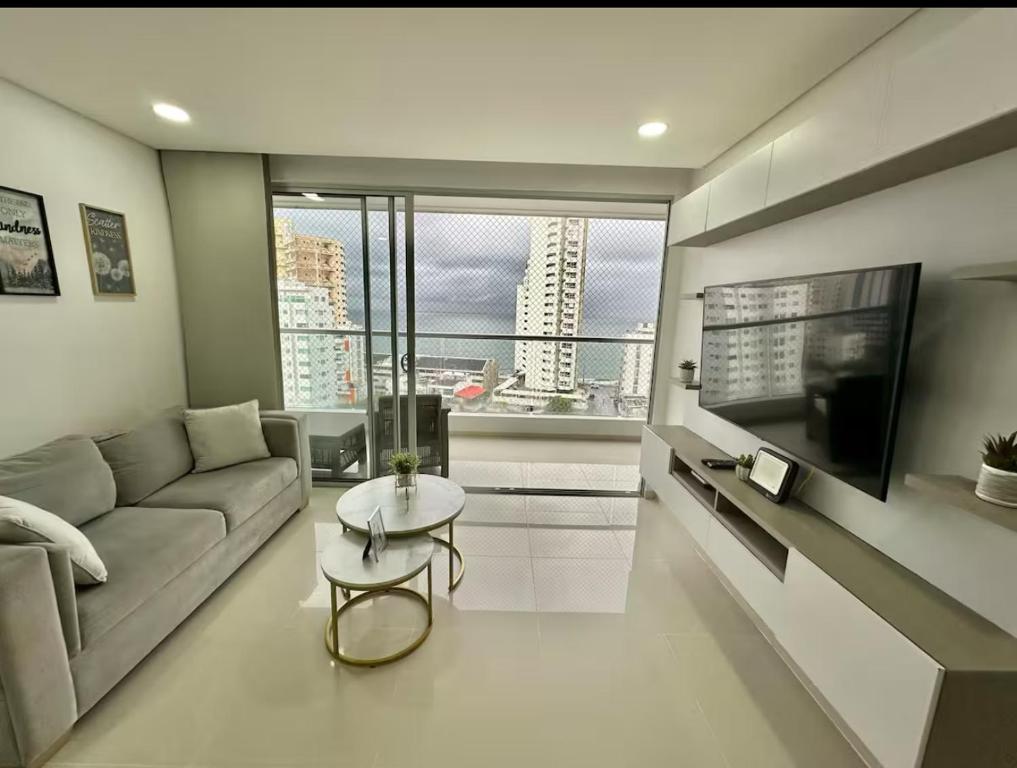 a living room with a couch and a tv at Tu apartamento en la playa piso 10 in Cartagena de Indias
