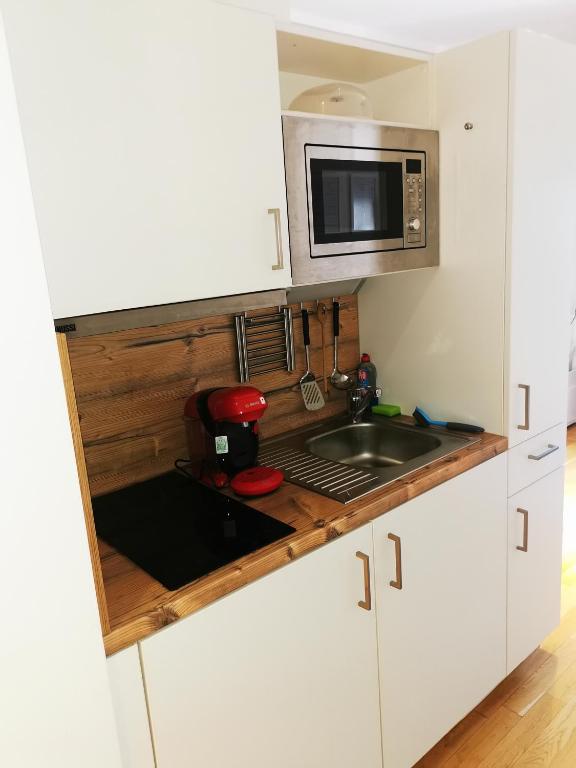a small kitchen with a sink and a microwave at Top-Apartment a.d. Messe in Munich