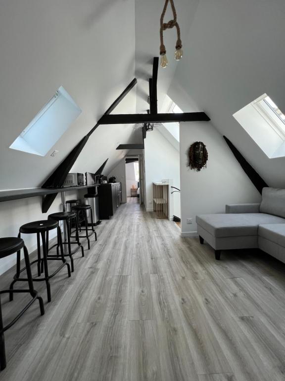 - un salon mansardé avec un canapé et des chaises dans l'établissement Dakar - vivez au cœur de la ville, à Reims