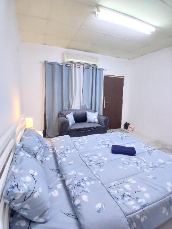 a bedroom with a large bed and a couch at Al Ain Mall Transient Studio in Al Ain