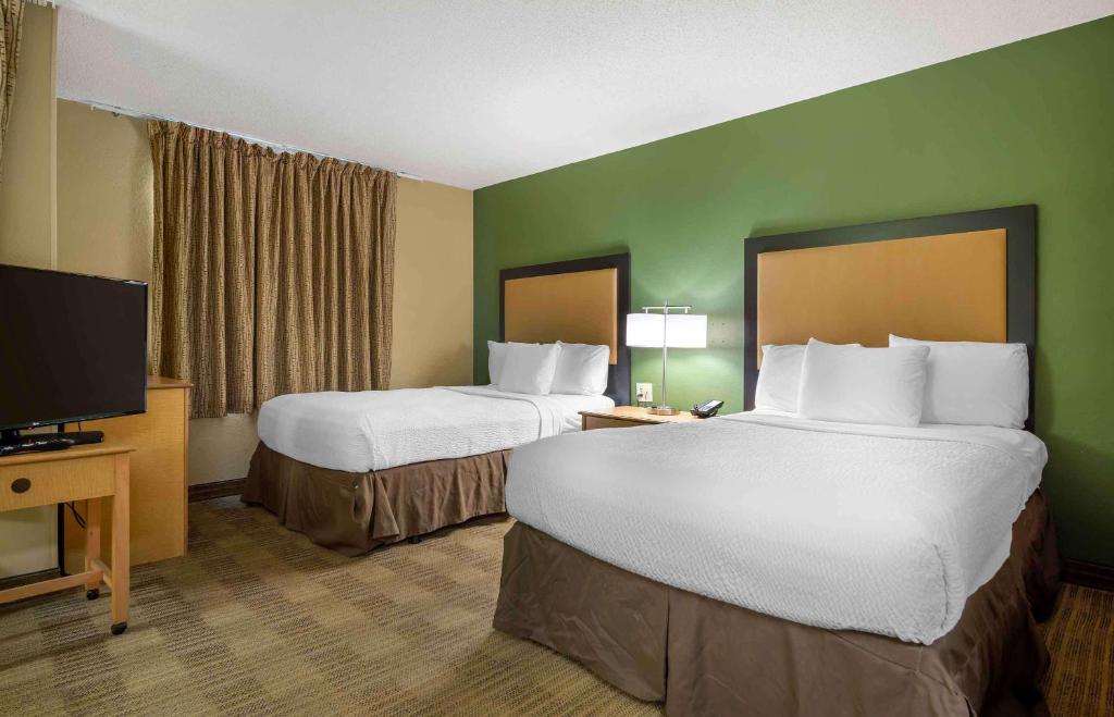 a hotel room with two beds and a flat screen tv at Extended Stay America Select Suites - Orlando - Lake Mary - 1040 Greenwood Blvd in Lake Mary