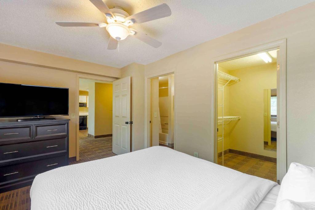 a bedroom with a bed and a flat screen tv at Extended Stay America Select Suites - Orlando - Lake Mary - 1040 Greenwood Blvd in Lake Mary