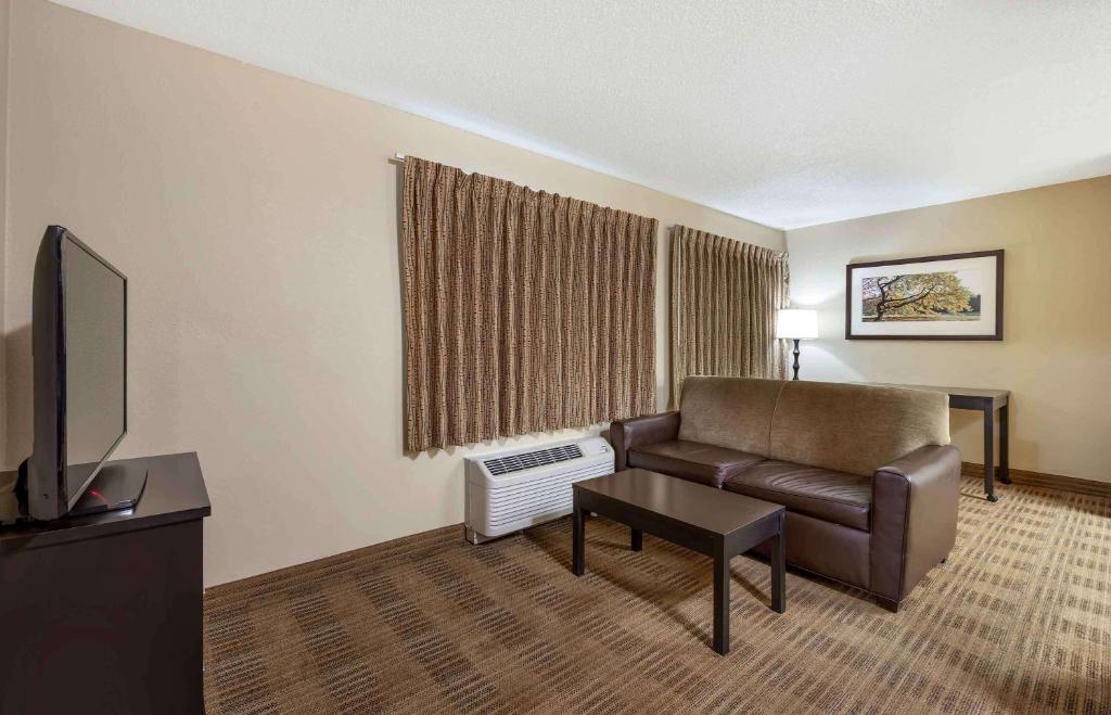 a living room with a couch and a television at Extended Stay America Select Suites - Orlando - Lake Mary - 1040 Greenwood Blvd in Lake Mary