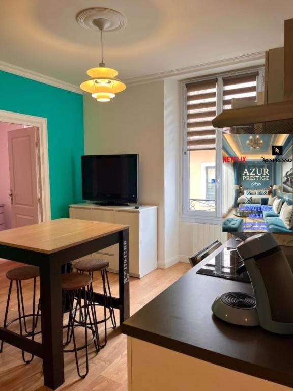un salon avec une table et une cuisine dans l'établissement AzurPrestigeStation5min TV Elegant Relaxing Chill, à Bellegarde-sur-Valserine