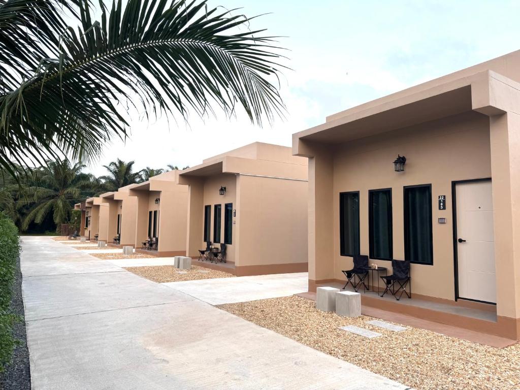 a row of houses with a palm tree in front at jj home resort in Phun Phin