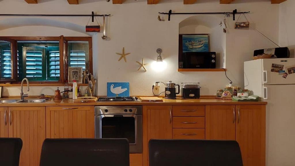una cocina con estufa y refrigerador en Seaside holiday house Sibenik - 23990, en Šibenik