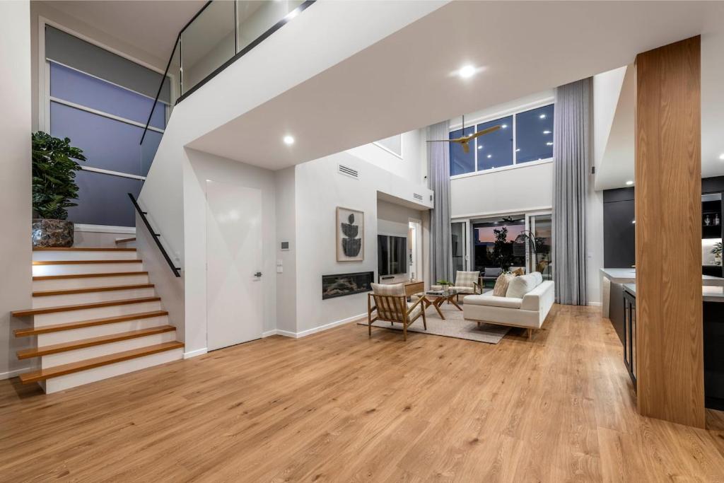 ein großes Wohnzimmer mit einer Treppe und einer Couch in der Unterkunft 4Bedroom Luxury home with Comfort & Stylish in Weston Creek