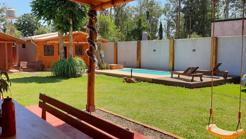 a backyard with a hammock and a swimming pool at Cabañas Juca in Puerto Iguazú