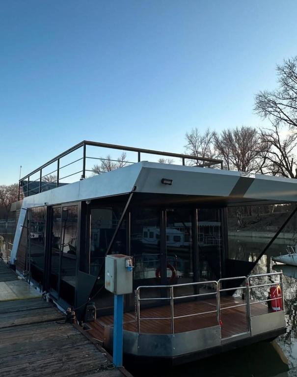a boat with a roof on the water at Bright Room Houseboat in Belgrade