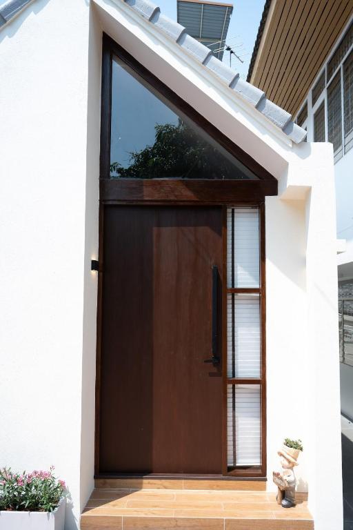 a brown door on a white house at Morya House in Bangkok