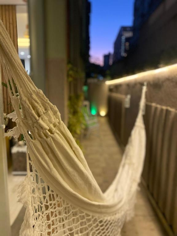 a white net hanging on a balcony with a street at Garden Moinhos de Vento in Porto Alegre