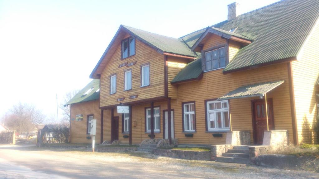 a large wooden house with a gambrel roof at Viesu Nams Jūras sapņi in Dundaga