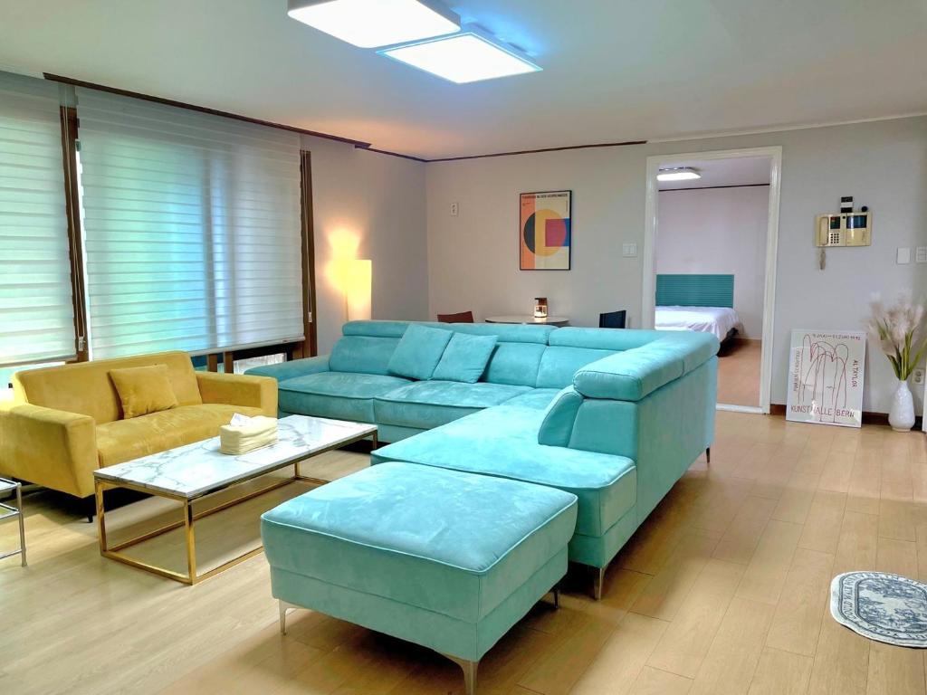 ソウルにあるMid-century design Modern houseの青いソファと椅子のあるリビングルーム